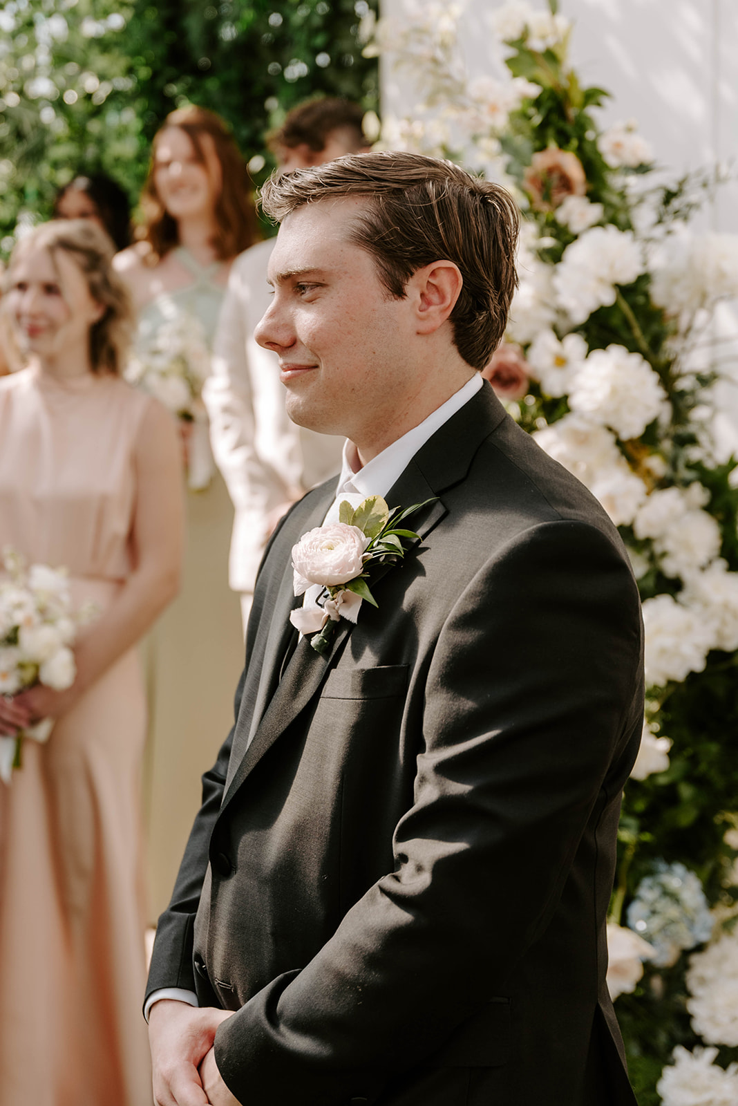 Groom watching his bride walk down the aisle.