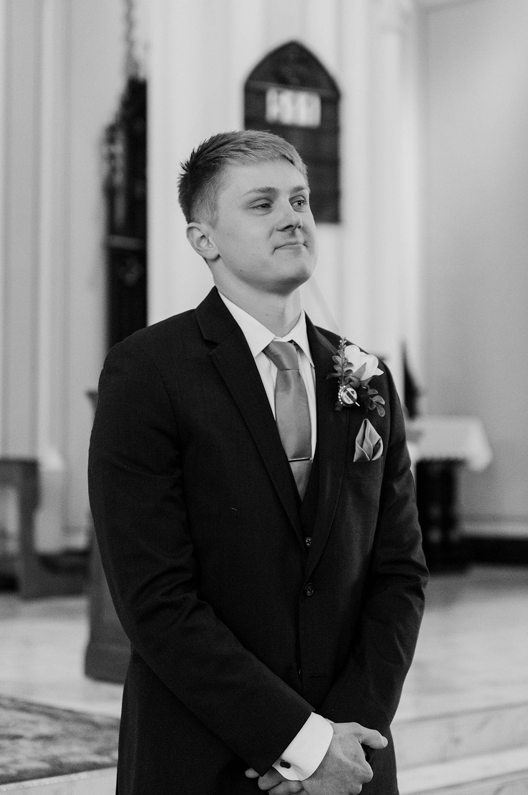 Groom smiling while waiting for his bride at the altar.